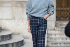 a lovely Christmas look in non-traditional colors, with a grey sweater, navy plaid pants, grey shoes and statement earrings