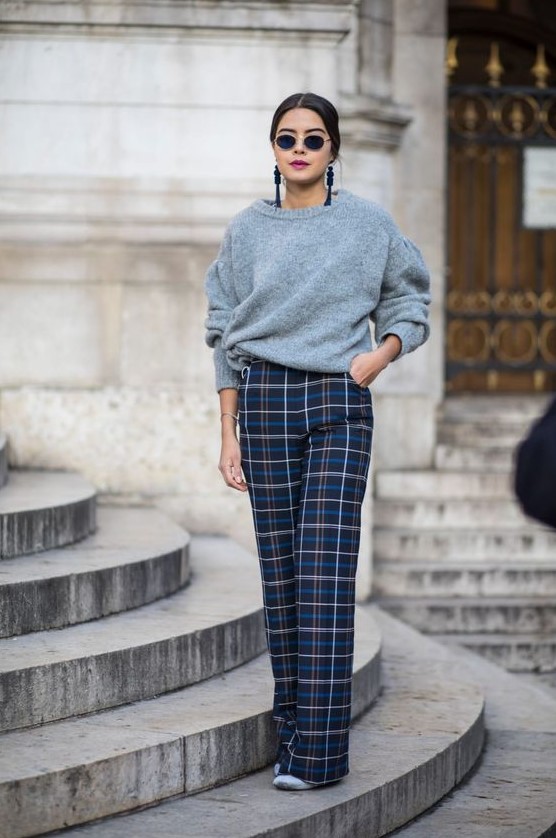 a lovely Christmas look in non-traditional colors, with a grey sweater, navy plaid pants, grey shoes and statement earrings