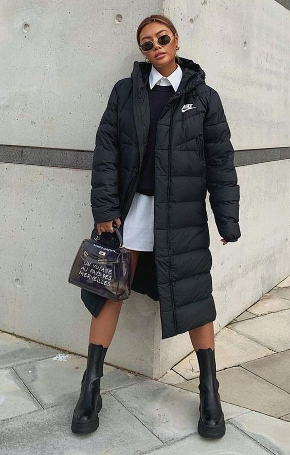 a monochromatic winter look with a white shirtdress, a black sweater, chunky boots, a black puffer coat and a clear bag