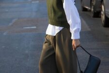 a neutral turtleneck, a white shirt, a green waistcoat, brown trousers and a black bag plus white trainers