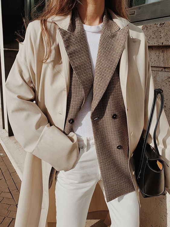 a pretty layered winter work outfit with a white t-shirt, a brown blazer, white jeans, a creamy trench and a black bag