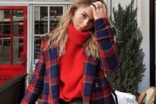 a red oversized sweater, black leather pants, a red and navy plaid coat compose a bold and colorful holiday look