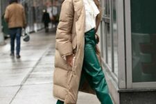 a refined winter look with a white blouse with a bow, emerald leather rousers, grey suede boots, a tan puffer coat