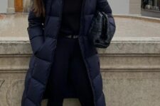 a sport chic winter look with a top, leggings, grey trainers and white socks, a navy puffer coat and a black bag