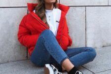 a sporty outfit with a white tee, blue skinnies, a red puffer jacket and black sneakers and socks