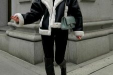 a stylish and elegant winter outfit with a black turtleneck and leggings, black boots and a shearling jacket plus a green bag