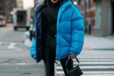 a total black look with leather pants, a sheer turtleneck over a top, lacquer boots, a bold blue puffer and a black bag