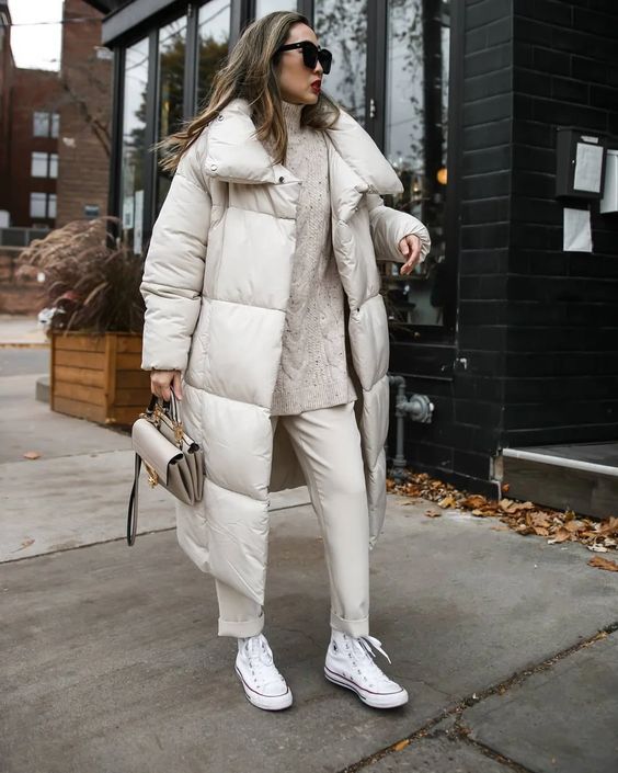 a total neutral winter look with a sweater, trousers, sneakers, a puffer coat and a bag is a lovely idea