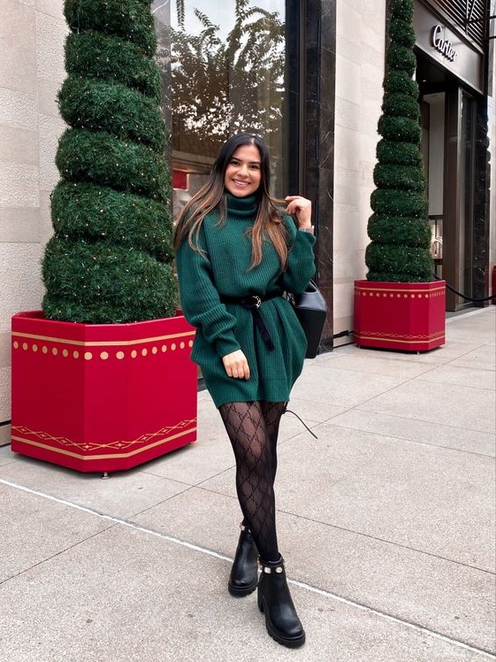 an emerald sweater mini dress with long sleeves and a turtleneck, a black belt, black printed tights and boots for the holidays