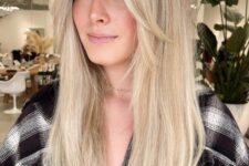long blonde hair with long curtain bangs that add interest to the look and bring dimension to the hairstyle