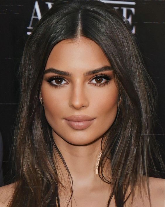Emily Ratajkowski wearing a sexy makeup with a glossy nude lip, a touch of blush and smokey eyes looks jaw-dropping