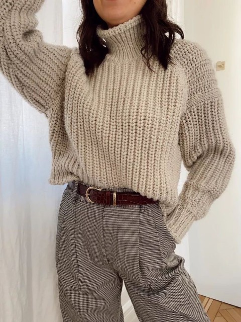 Outfit with a beige knitted loose turtleneck sweater, a brown leather belt and checked high-waisted pants