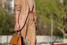 With beige turtleneck, brown leather belt, bown leather bag and brown leather shoes