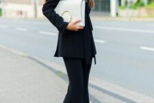 With black patent leather high heel shoes and white and golden leather clutch
