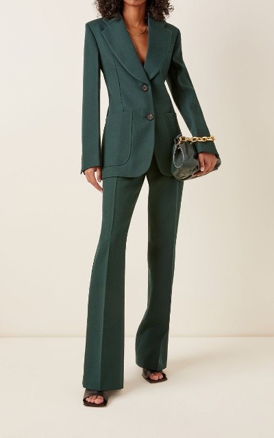 With golden necklace, emerald green patent leather chain strap bag and black leather heeled shoes