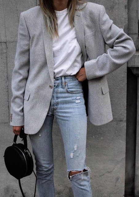 With light blue distressed high-waisted jeans and black leather rounded bag