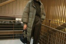 a black sweater, brown leather pants, black boots and a bag plus a green puffer coat for winter