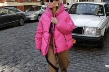 a catchy winter look with rust trousers, white and black Chelsea boots, a hot pink puffer jacket