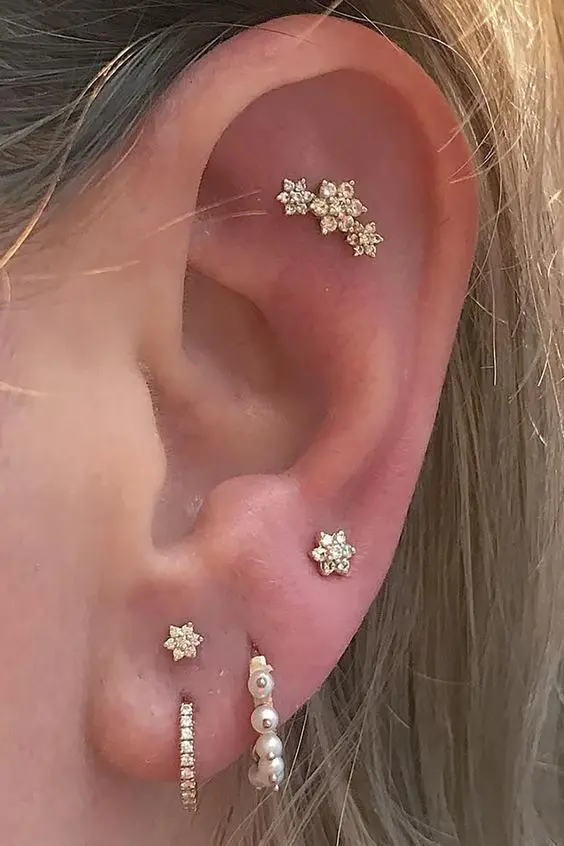 a curated ear with a flat, stacked lobe and high lobe piercing, with studs and hoops is a very stylish solution