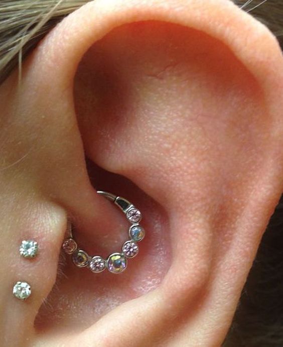 a daith and double tragus piercing done with studs and a hoop with rhinestones are a lovely combo