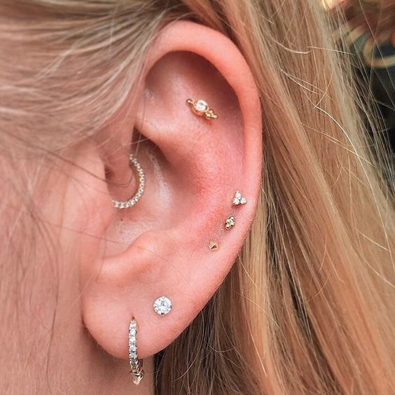 a double lobe, daith, flat and triple mid helix piercing done with rhinesotne studs and hoops are amazing