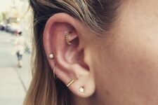 a double lobe, mid helix and rook piercing with gold studs and hoops with rhinestones look amazing
