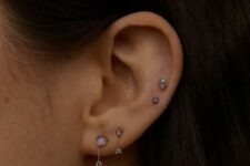 a double lobe plus a double mid helix piercing done with lilac and blue studs and chains with studs