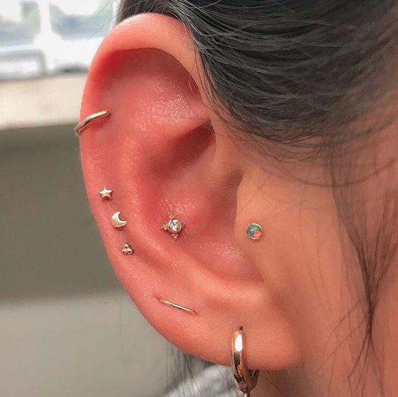 a helix, triple mid helix, orbital, lobe and conch plus tragus piercing with tiny white gold studs and hoops is breathtaking