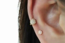 a high lobe and a low helix piercing done with a rhinestone stud and a hoop look very unusual