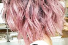 a lob haircut with waves done in pastel pink, with a darker root, looks great and chic