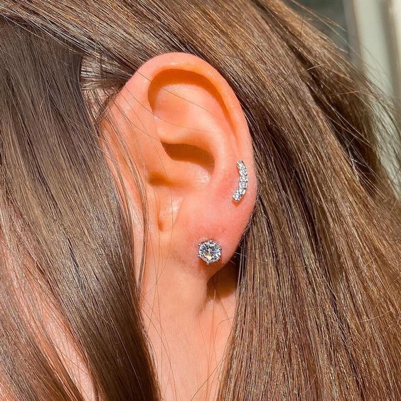 a love and high lobe or low helix piercing done with cool rhinestone jewelry look gorgeous together
