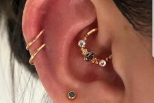 a number of stacked ear piercings include stacked lobe, helix and daith ones done with gold hoops and studs is amazing