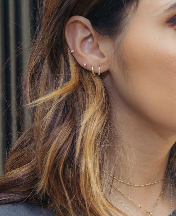 a triple lobe plus a mid helix piercing with gold and rhinestone hoops and studs are great for minimalists