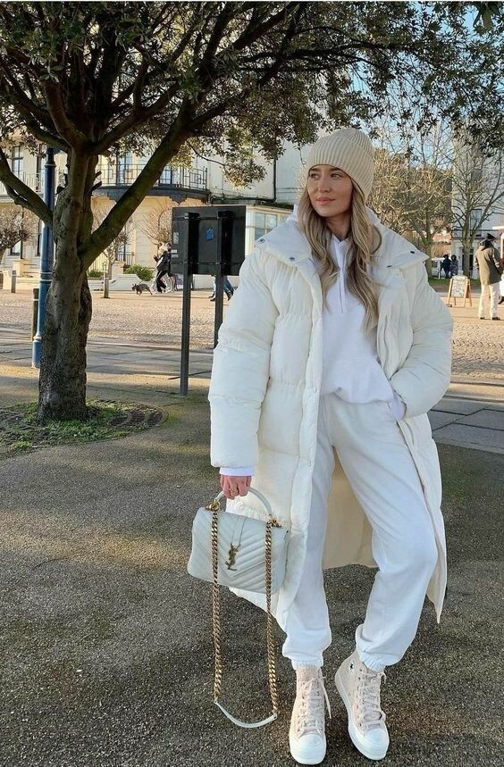 an all-neutral winter look with a creamy tracksuit, neutral sneakers and a puffer coat, a beige beanie and a white bag