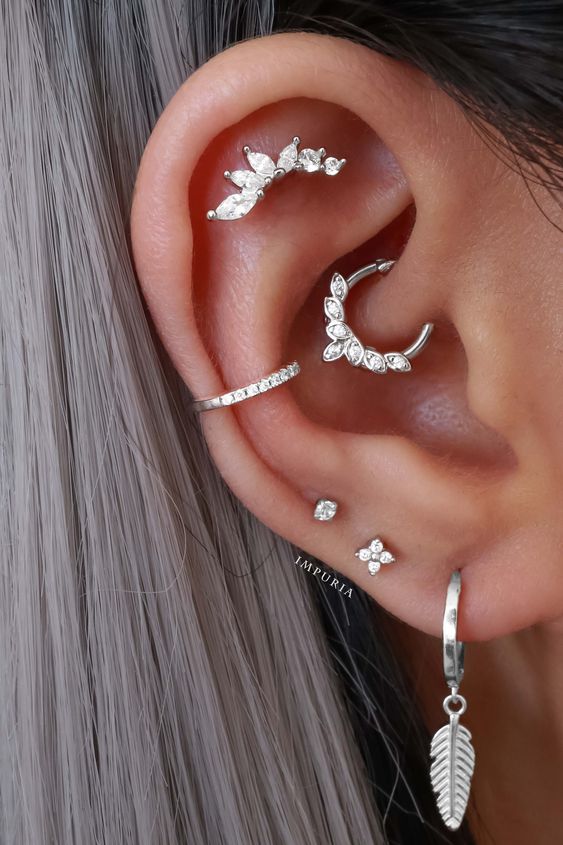 beautiful and chic ear styling with stacked and high lobe, conch and daith, flat piercings done with white gold hoops and studs