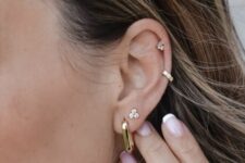 beautiful ear styling with a double lobe, mid helix and upper helix piercings, with gold hoops and studs