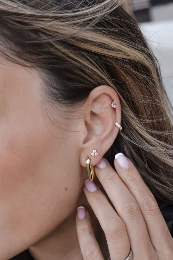 beautiful ear styling with a double lobe, mid helix and upper helix piercings, with gold hoops and studs