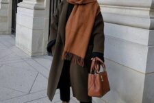 black jeans, brown boots, a dark grey midi coat, a beige scarf and an amber bag are a great combo for winter