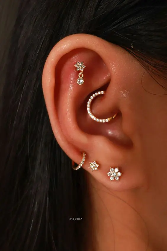 bold and glam ear styling with stacked lobe, a high lobe, flat and daith piercings done with beautiful rhinestone hoops and studs