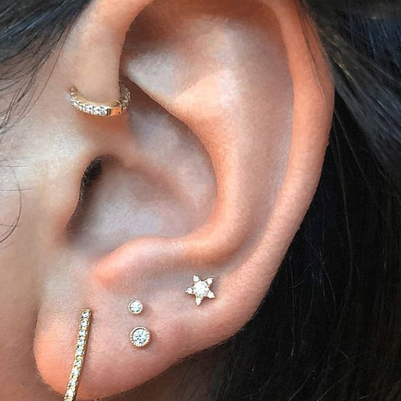 chic and minimal ear styling with a stacked and high lobe piercing and a forward helix done with studs and hoops