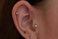 chic and modern ear styling done with a tragus, forward and usual helix plus stacked lobe and high lobe piercing and lovely studs and a hoop