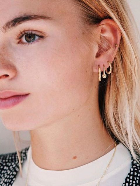 cool ear styling with a triple lobe nad a mid helix piercing done with gold hoops and a small gold stud