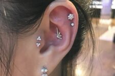 creative ear styling with an upper conch, a double helix, double tragus and lobe piercings, with catchy studs