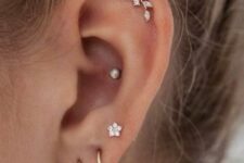 delicate ear styling with stacked and high lobe, flat and conch piercings accented with hoops and studs