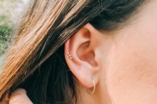 elegant and simple ear styling with a lobe and mid helix piercing, with studs and a hoop for minimalists