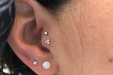 elegant ear styling with a double lobe and double tragus piercing done with rhinestone studs is all cool