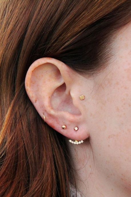 elegant ear styling with a double lobe, mid helix and tragus piercings accented with gold hoops and studs