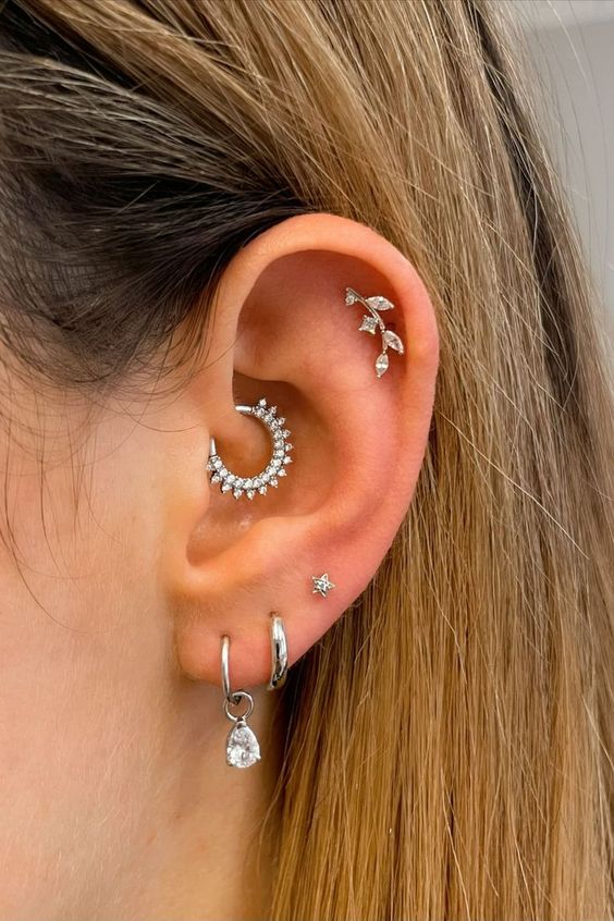 elegant ear styling with stacked lobe, high lobe, daith and flat piercings done with white gold hoops and studs looks wow