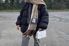 grey sweatpants, a black puffer jacket, white sneakers, a white bag and a printed scarf to accent the outfit
