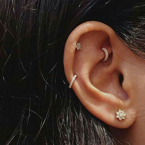 minimal ear styling with a lobe, mid helix, upper helix and rook piercings done with cool and shiny studs and hoops